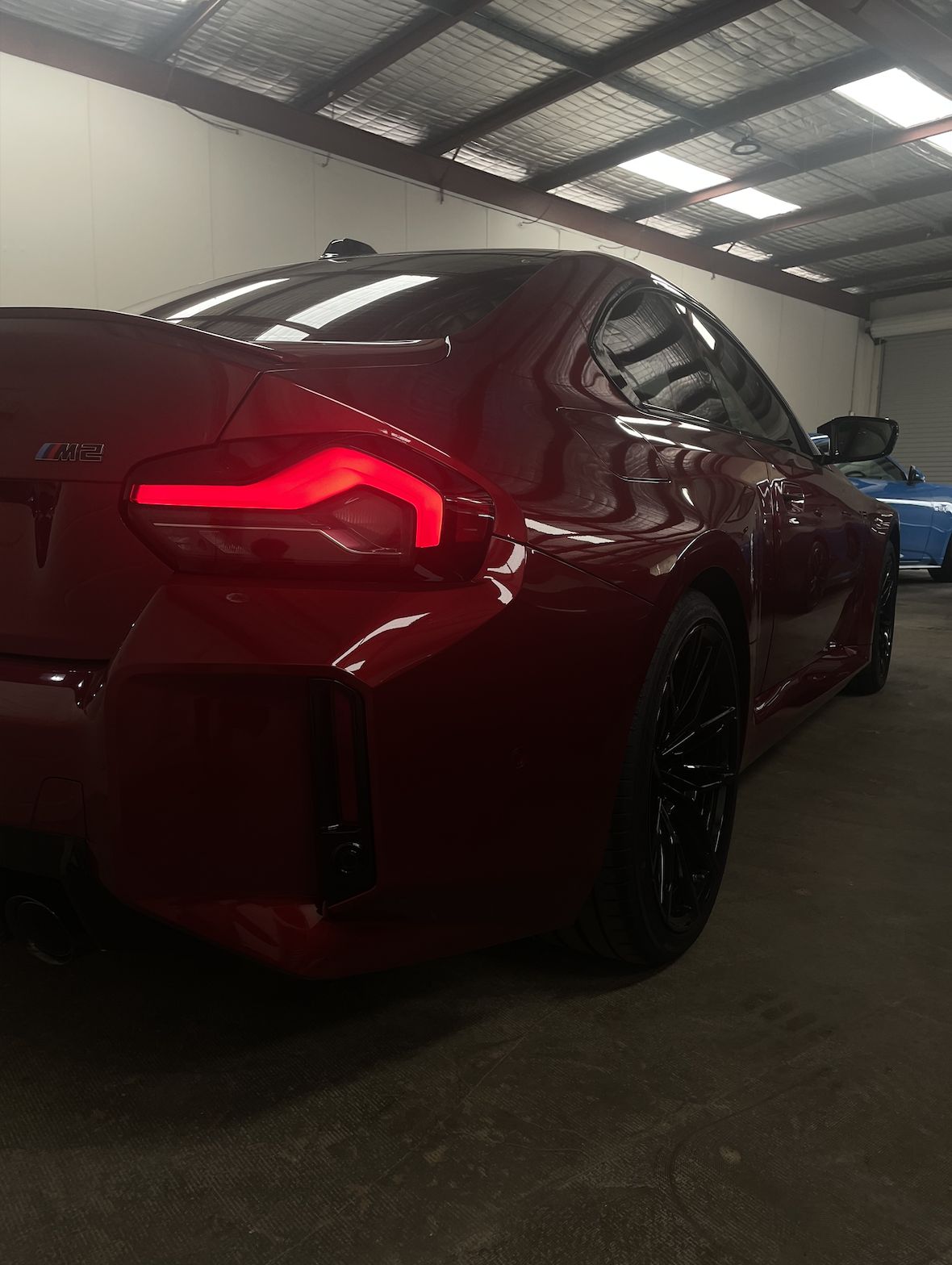 Red BMW M2 rear in the detailing bay